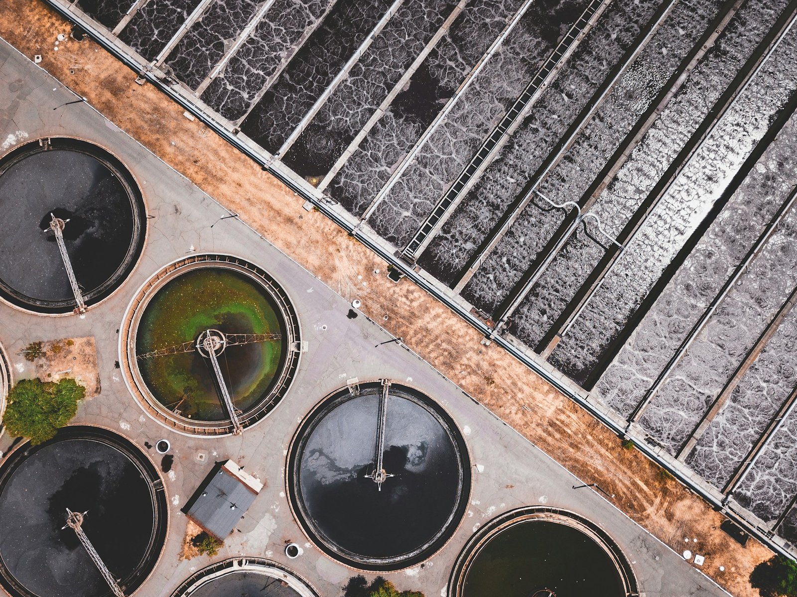 Sedimentation basins at a water treatment plant, with treated water flowing over weir plates at sunrise